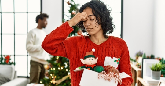 frustrated woman taking down Christmas decorations